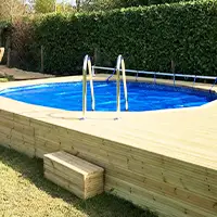 A small above ground pool set in raised wooden decking.
