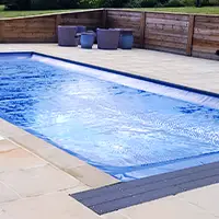 An outdoor swimming pool that has been covered up with a pool safety cover.