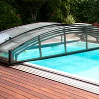 A detail shot of a retractable swimming pool enclosure in the open position over a small plunge pool.