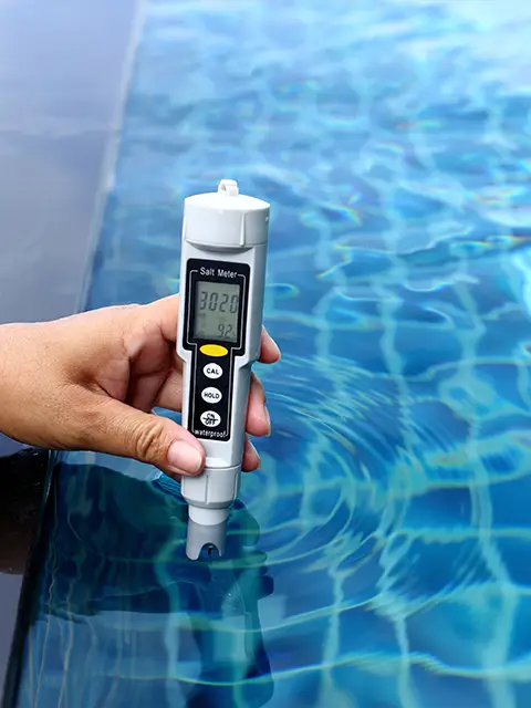 Close up of a salt meter checking the levels of a domestic swimming pool during a weekly maintenance check.