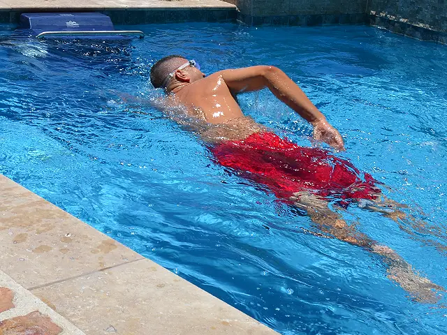 A swimmer in a small pool swimming against the current created by an Endless Pool Unit.