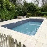 A recently refurbished swimming pool surrounded by a safety fence.